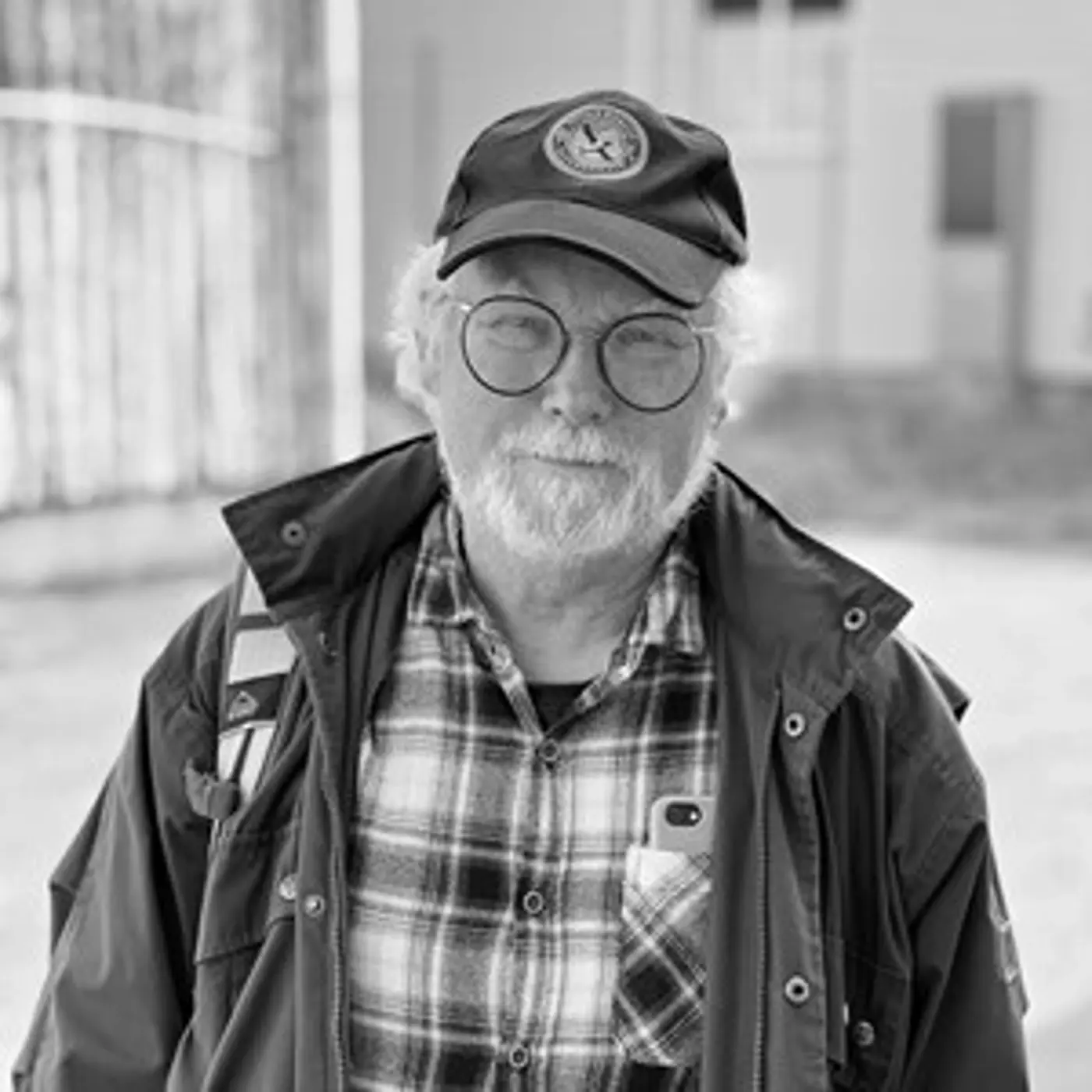En äldre man med glasögon och keps.