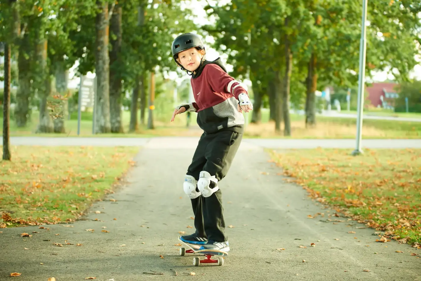 En yngre kille som åker skateboard med hjälm