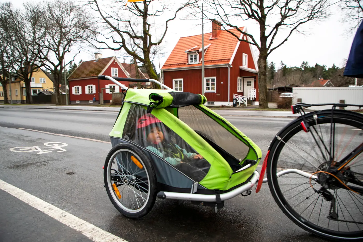 Ett småbarn barn blir skjutsad i en cykelvagn.