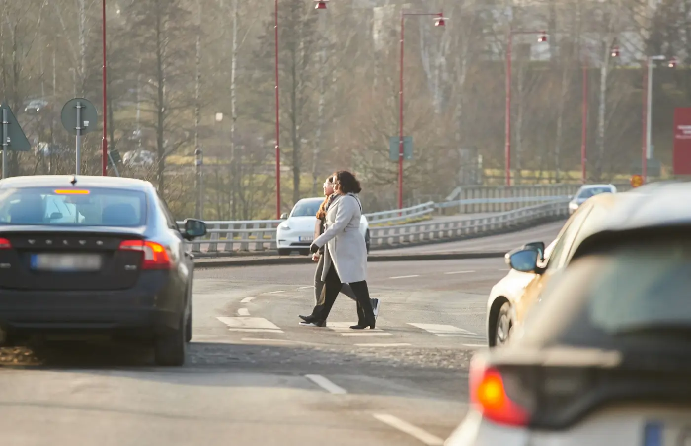Två personer går över ett trafikerat övergångsställe.