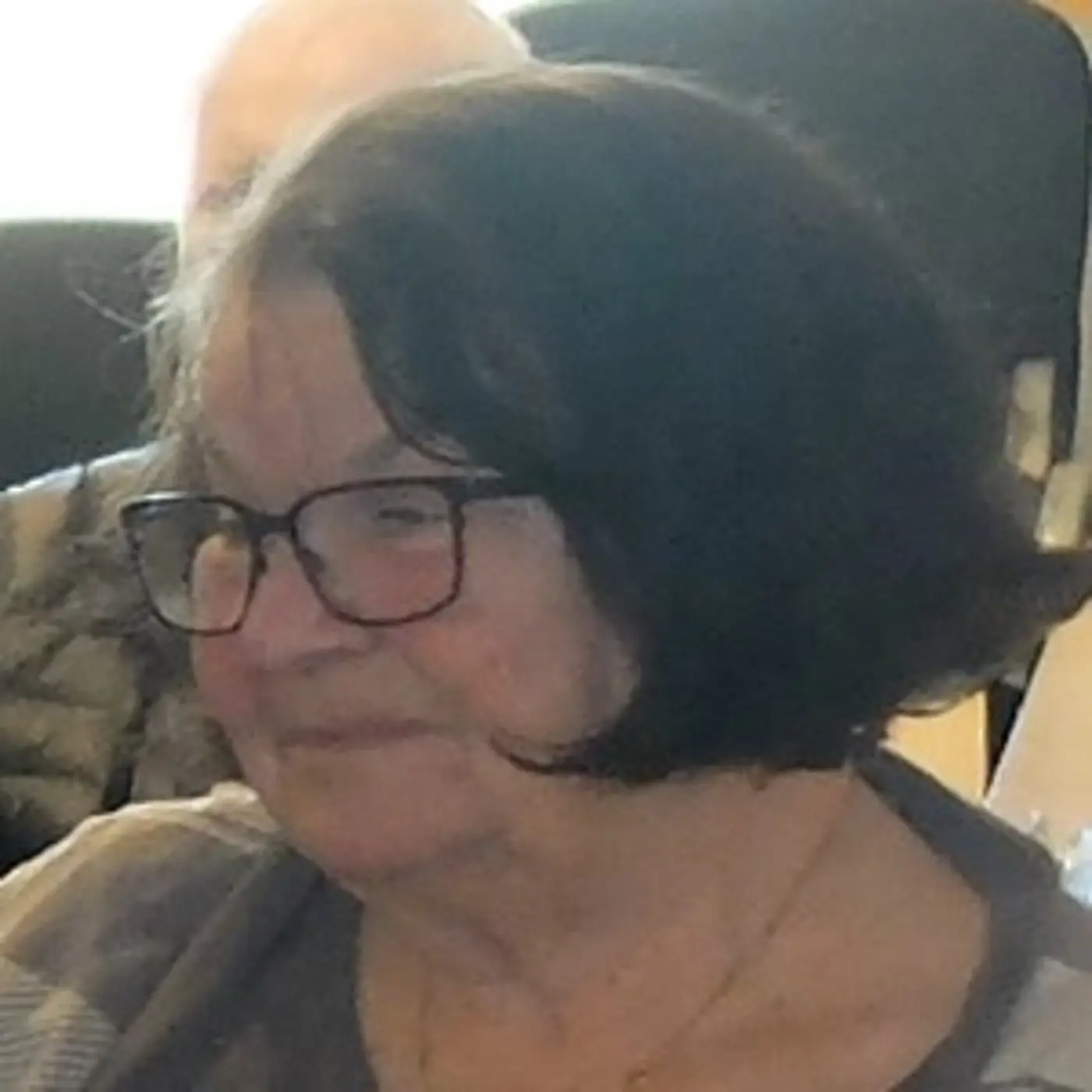 En äldre kvinna med kort hår och glasögon.