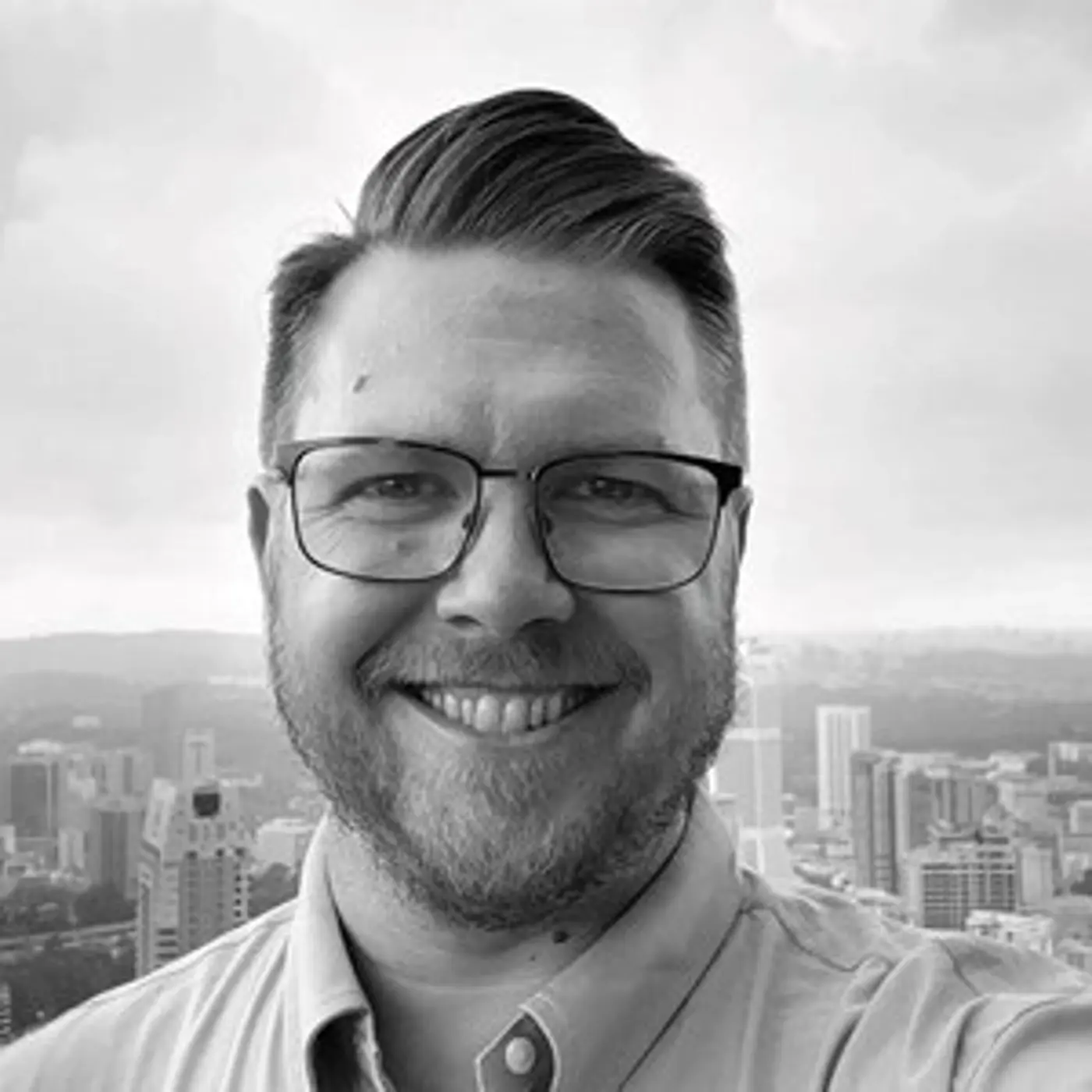 En leende man med glasögon.