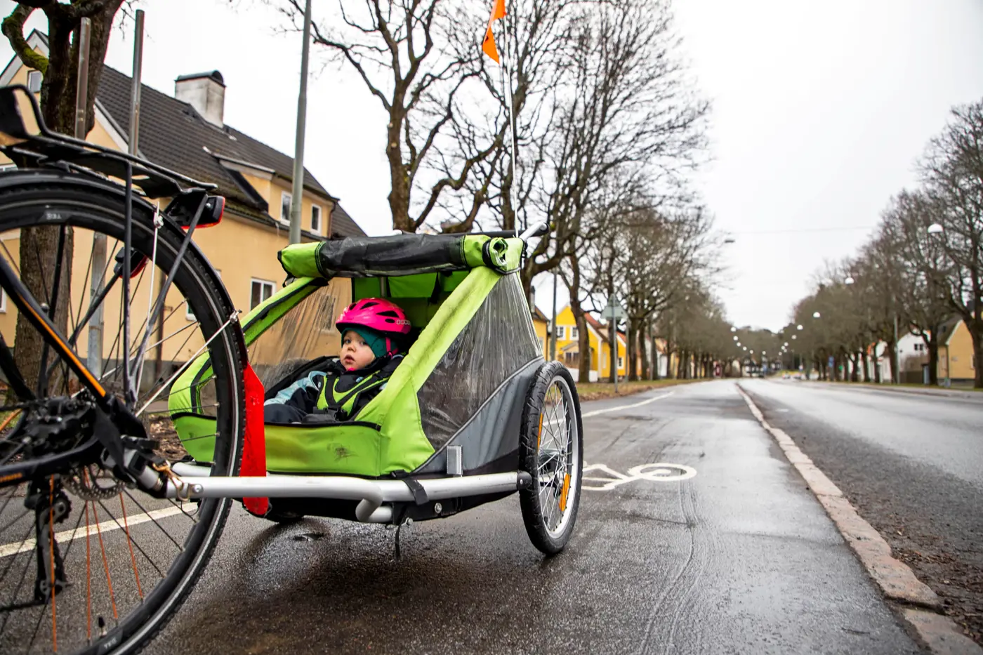 Ett småbarn barn blir skjutsad i en cykelvagn.
