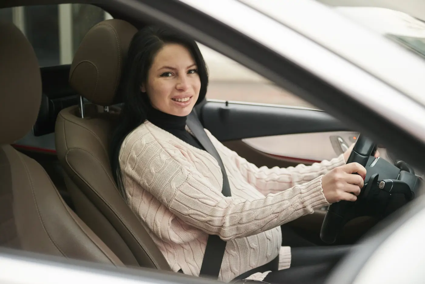 En gravid kvinna kör bil.