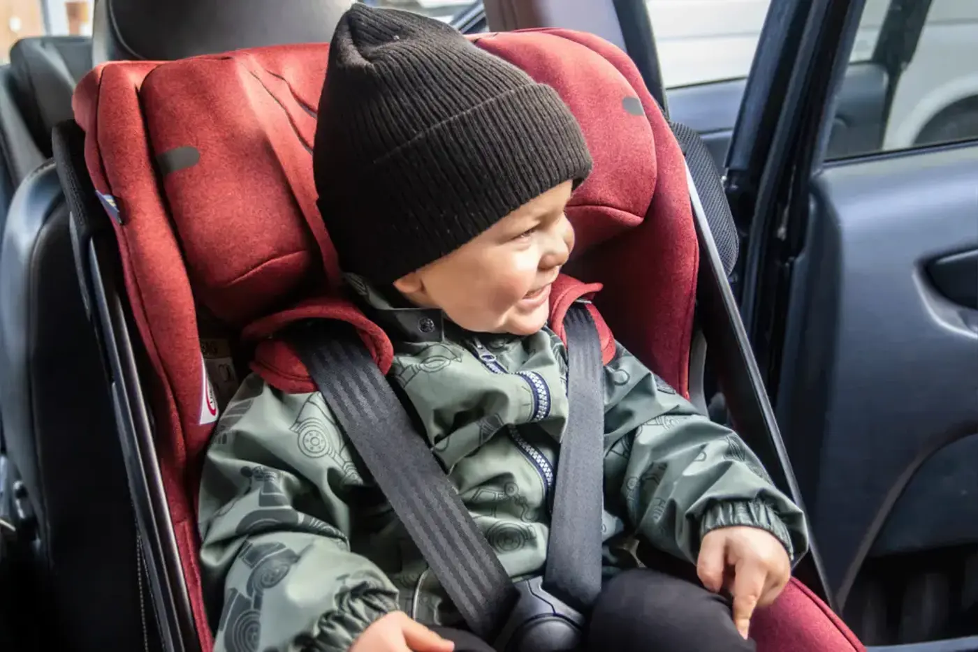 Barn i ettårsålders som sitter i en bakåtvänd bilbarnstol.