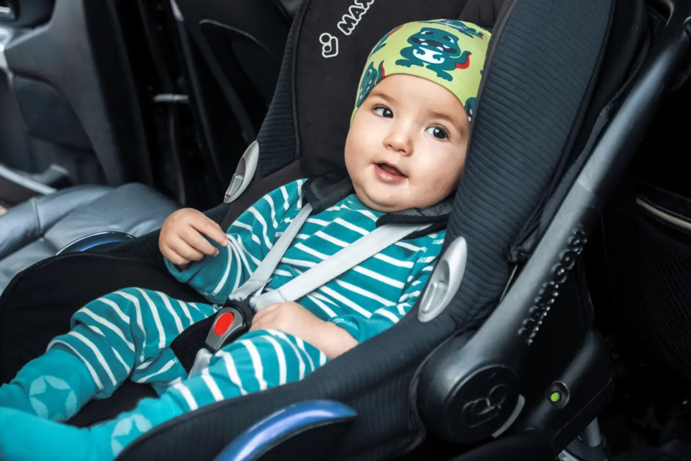 En bebis sitter i en bakåtvänd bilbarnstol.
