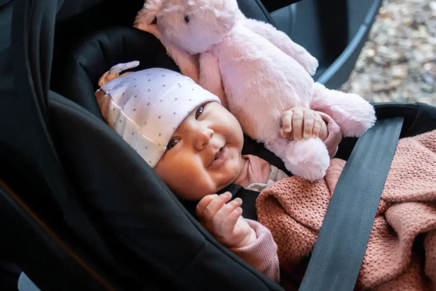 En bebis ligger i ett babyskydd.