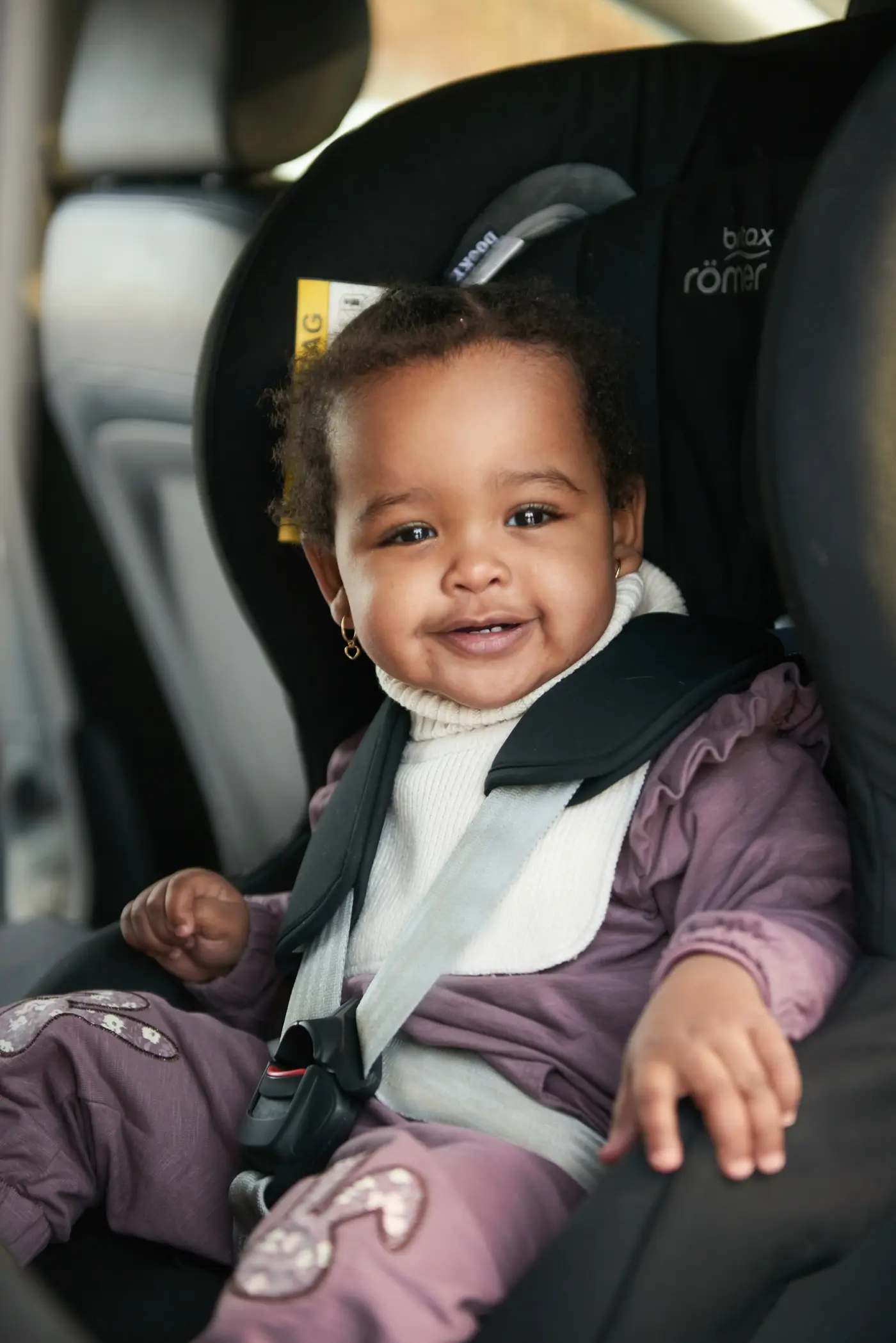 Ett småbarn sitter i en bakåtvänd bilbarnstol.