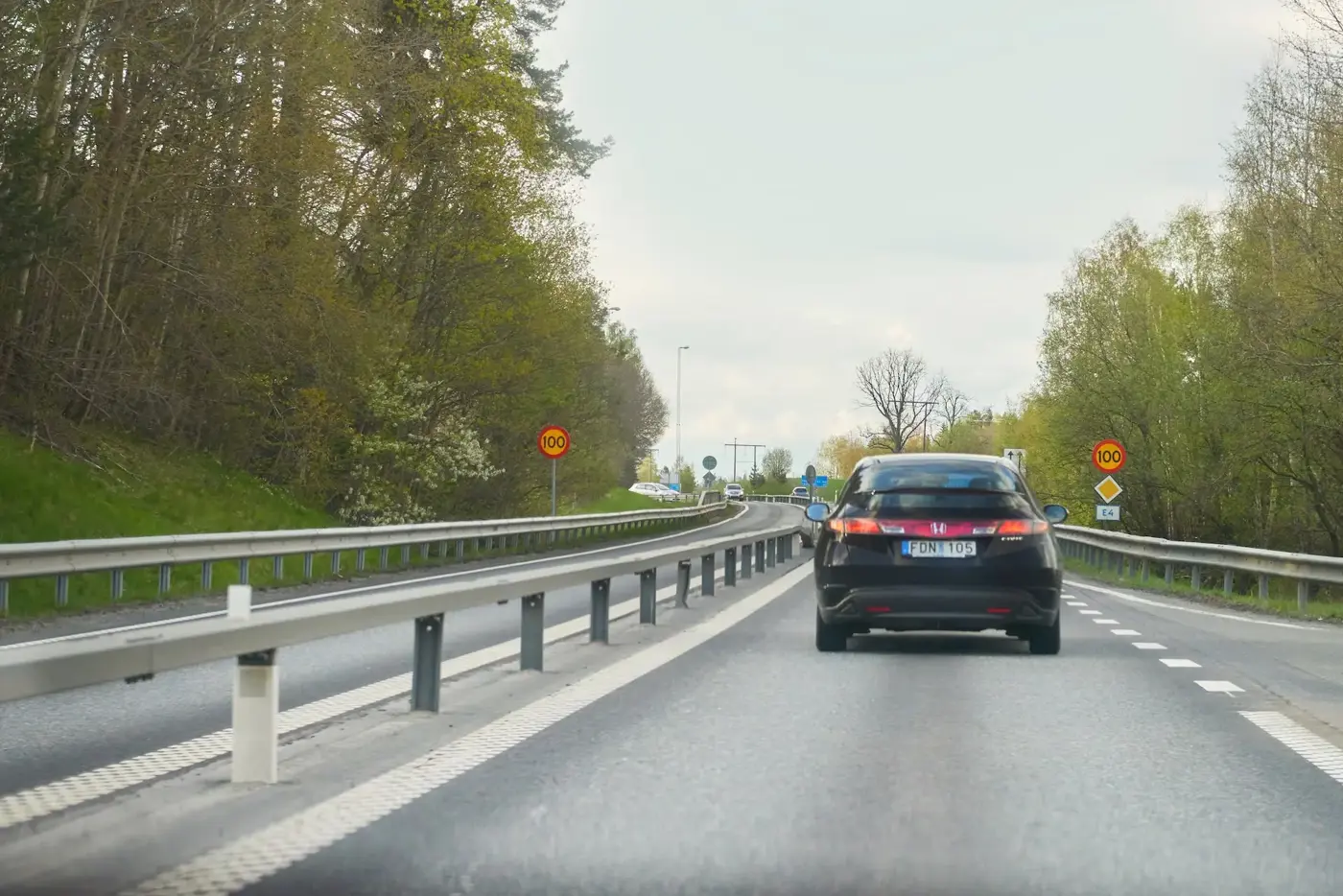 Bil bakifrån på huvudled med hastighet 100 kilometer i timmen