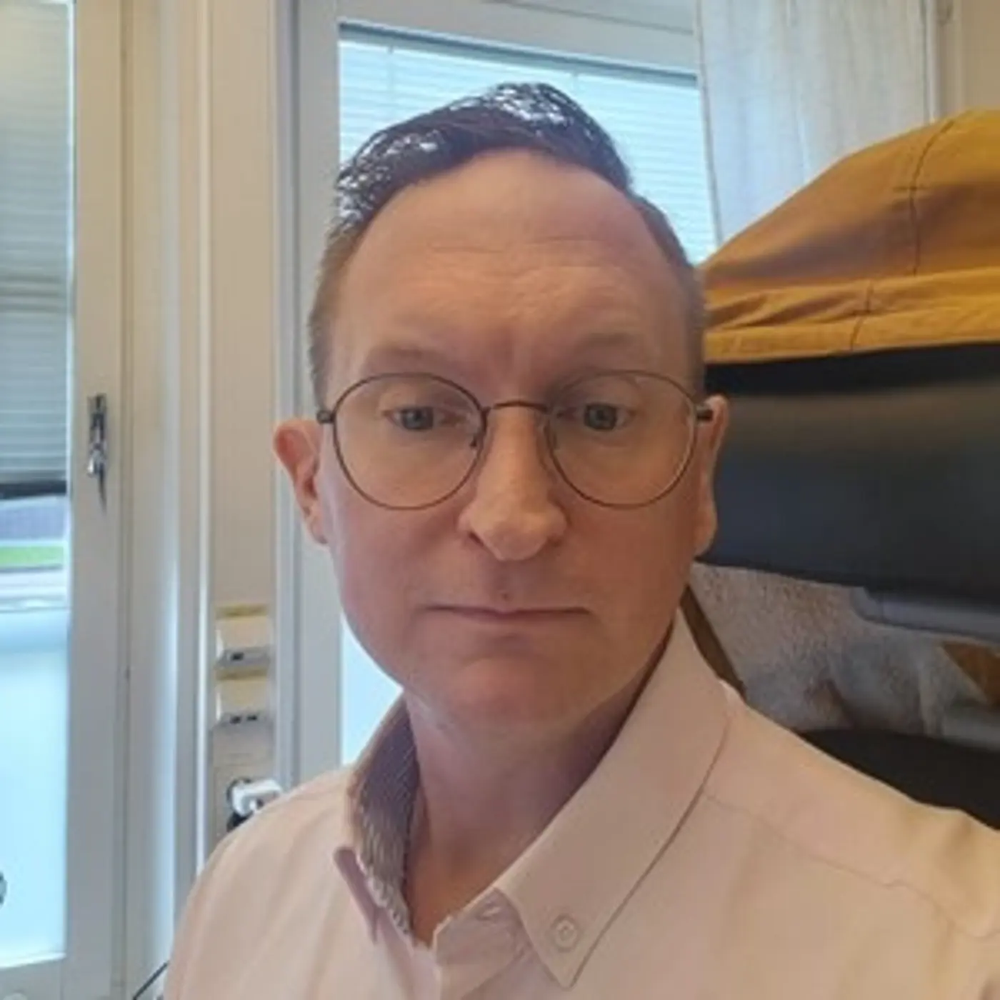 En man med ljus skjorta och glasögon.