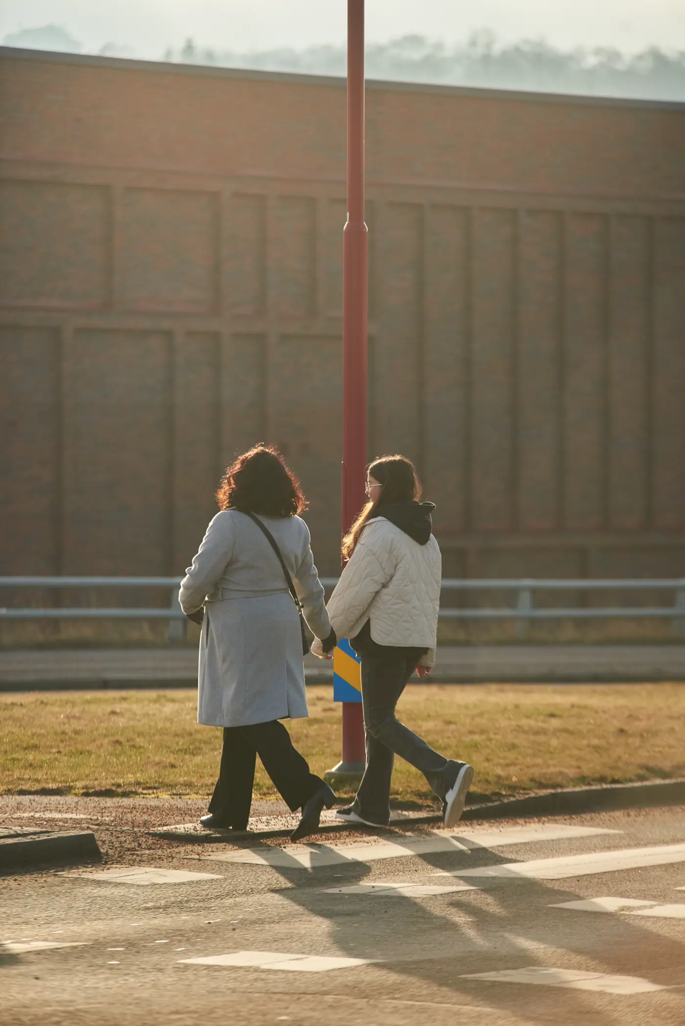 Två personer går över ett övergångsställe.