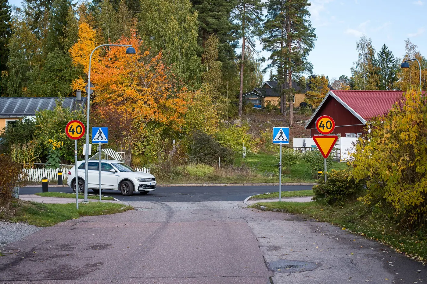 En bil passerar ett övergångsställe för att svänga in på en väg i ett bostadsområde.