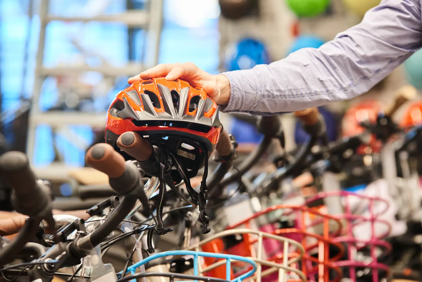 En person balanserar en hjälm på ett cykelstyre i en cykelbutik.