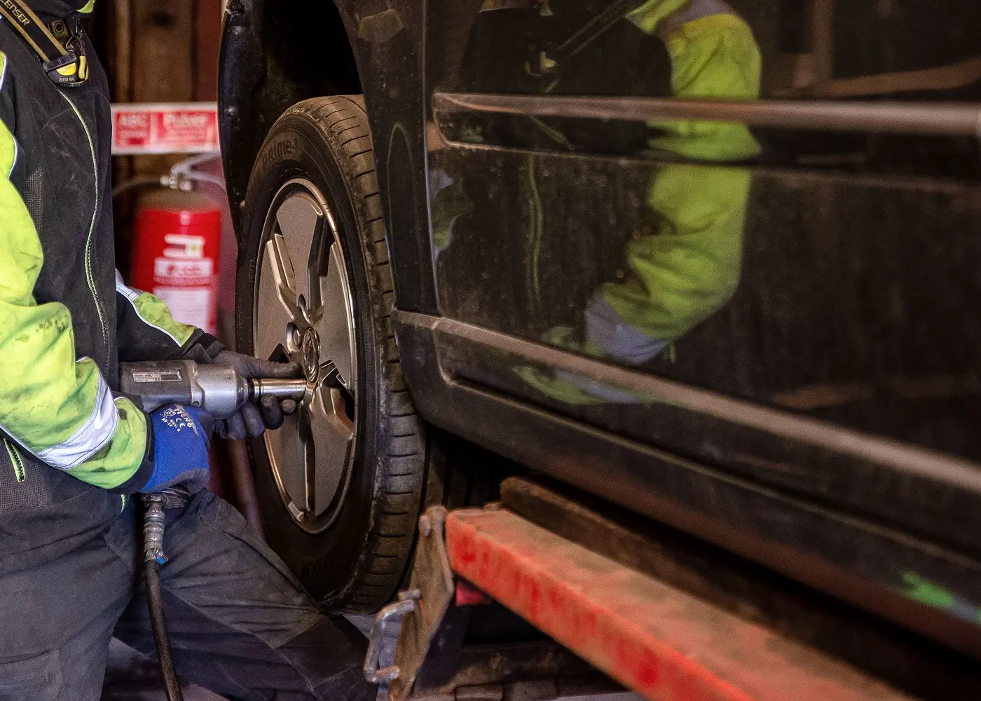 En man byter däck på en bil.