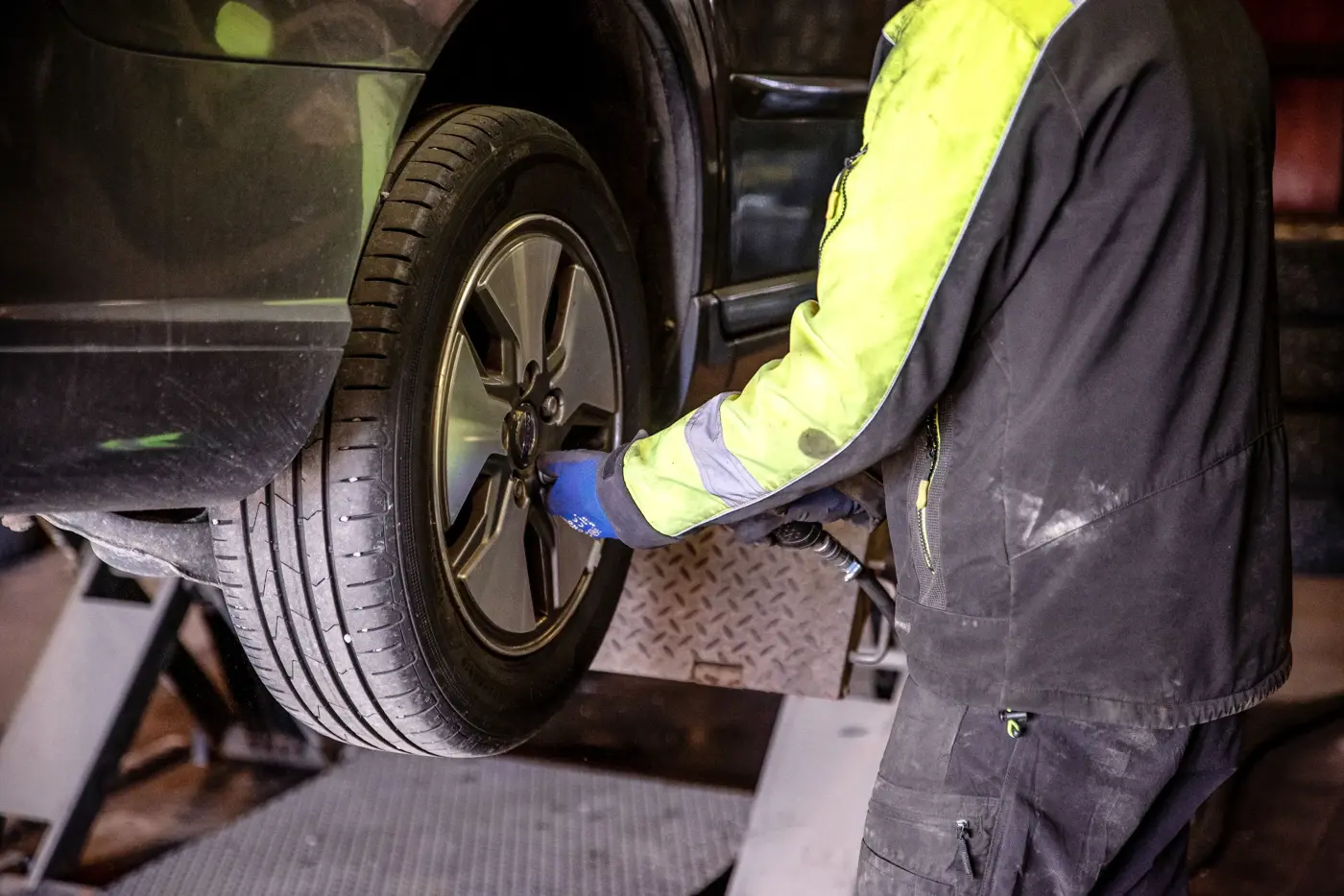 En man byter däck på en bil.