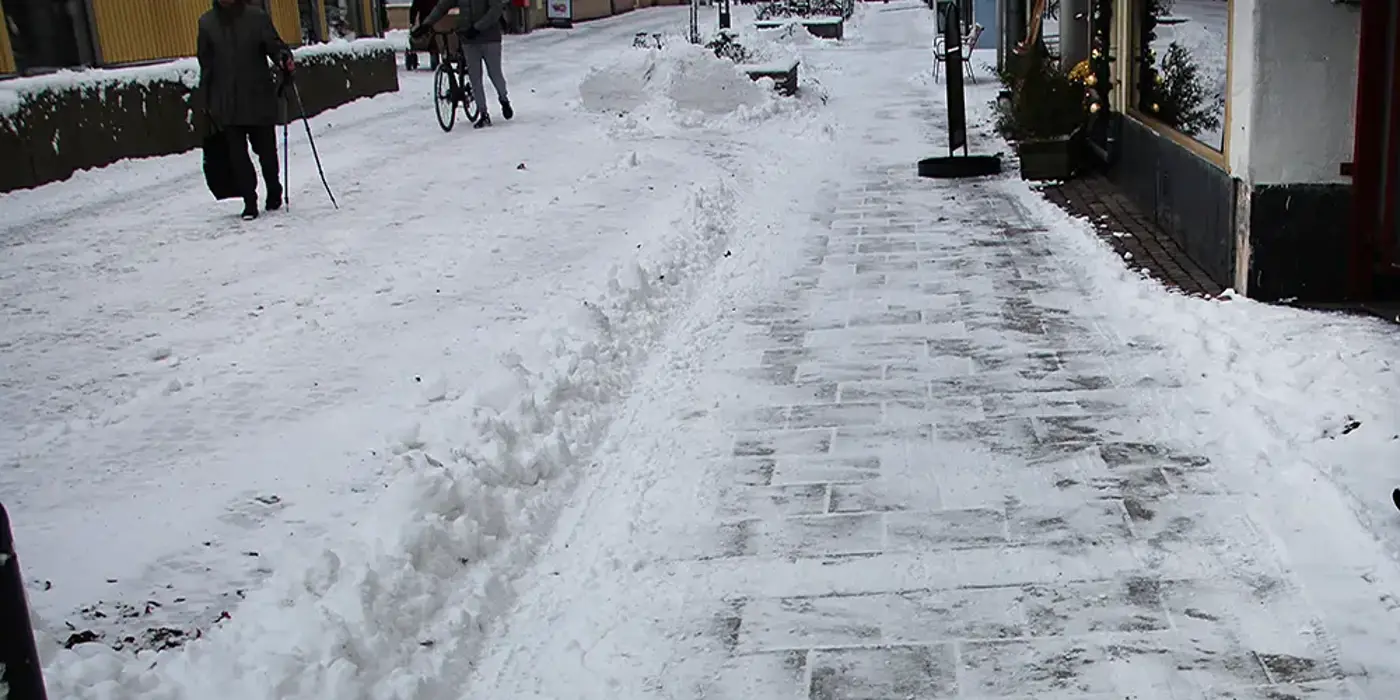 En snöfylld trottoar har precis plogats.