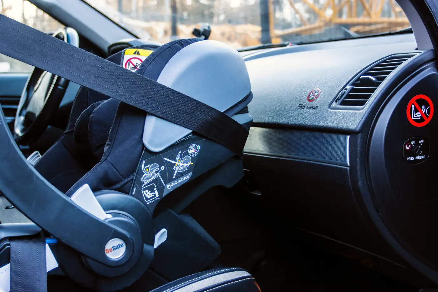 Närbild på ett babyskydd som satts fast i framsätet på en bil.
