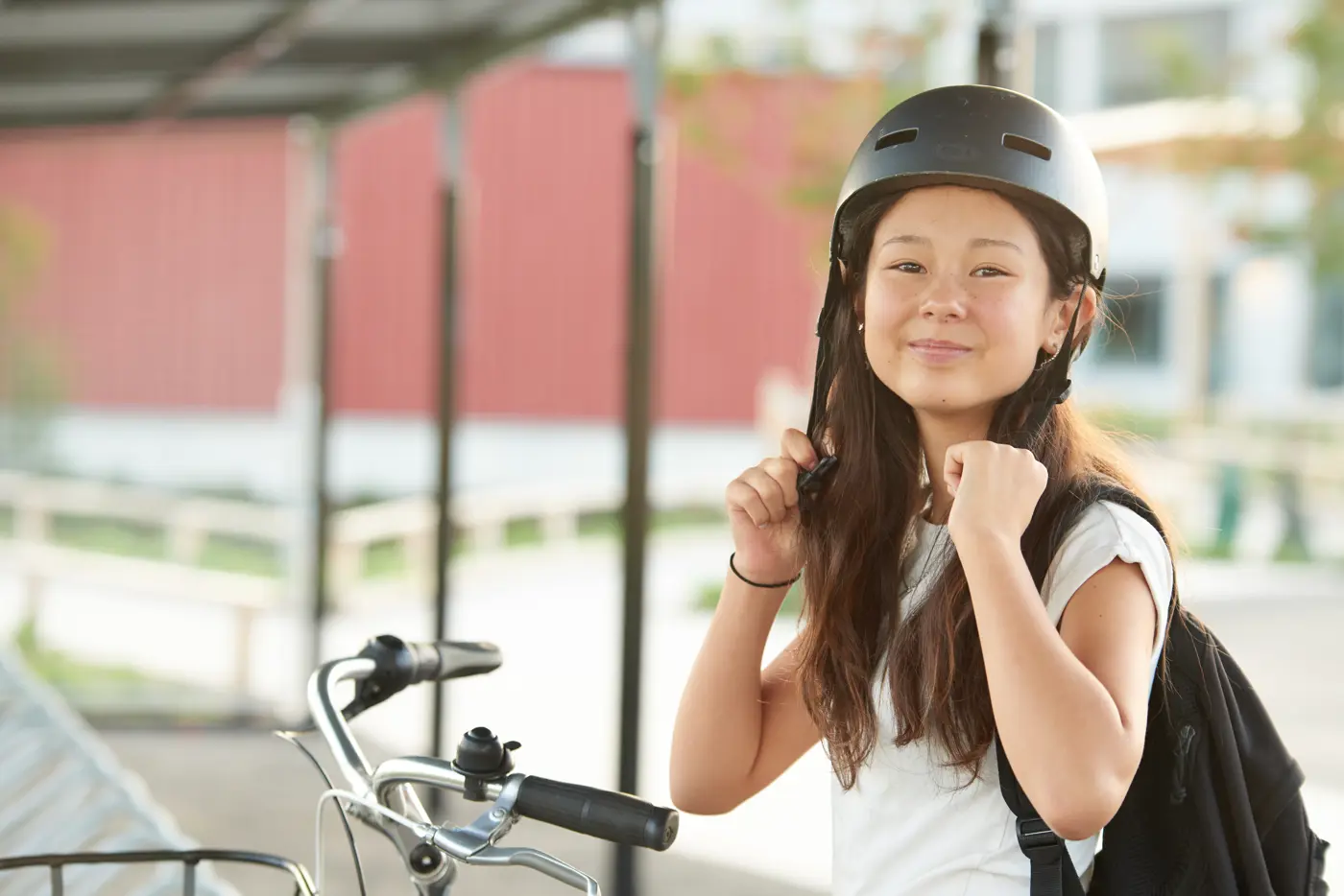 Ett skolbarn sätter på sig sin cykelhjälm