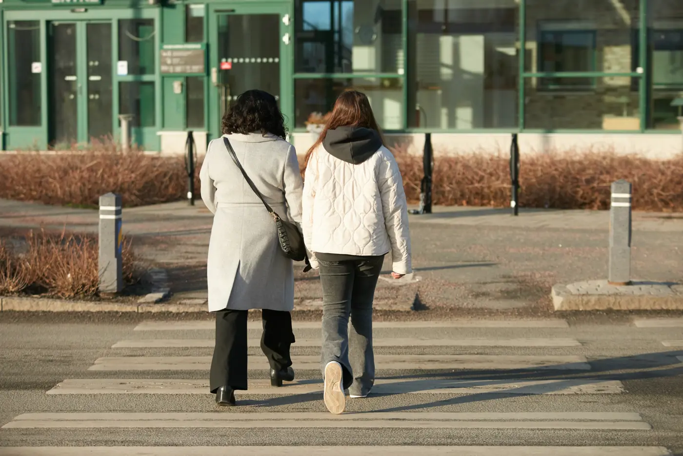 En mamma och hennes dotter passerar ett övergångsställe.