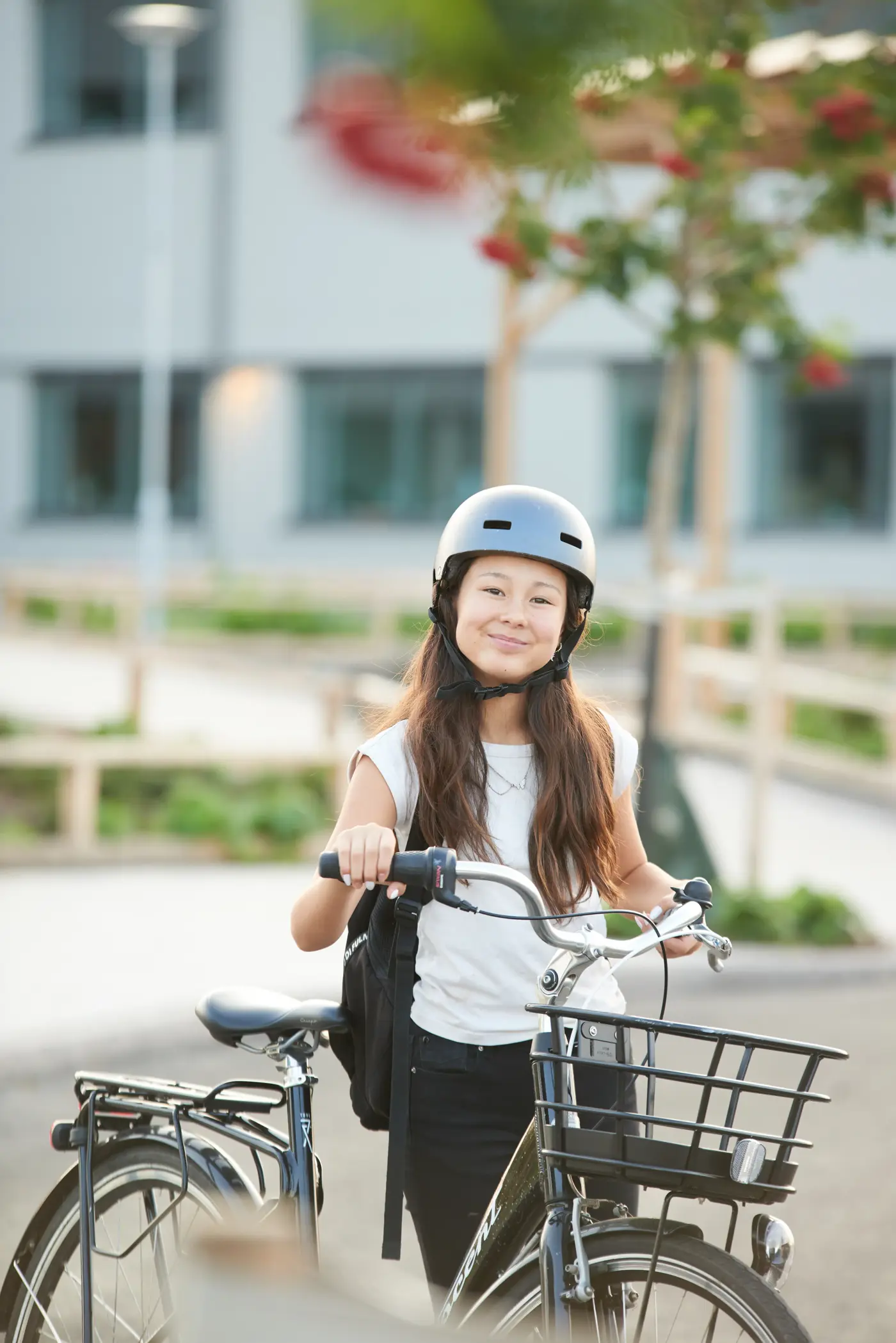 Skolungdom som står brevid sin cykel och ler