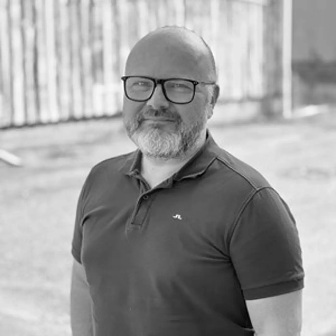 En man med glasögon och skägg.