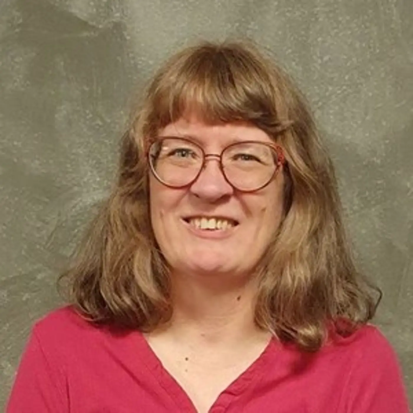 En leende kvinna med glasögon.