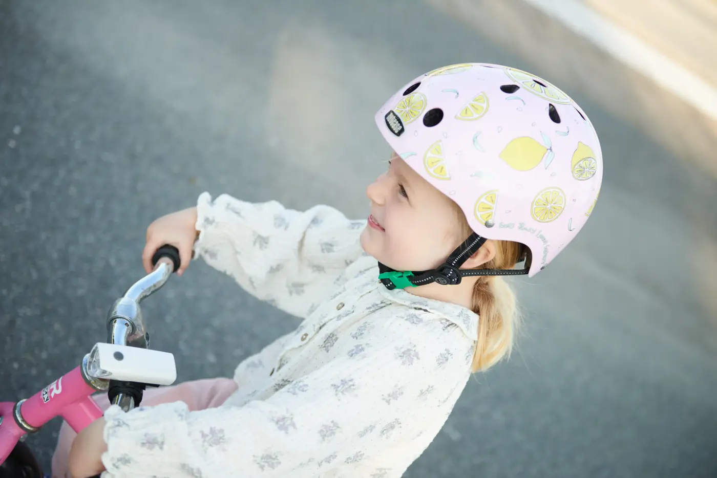 Småbarn på lekfordon med en småbarnshjälm.