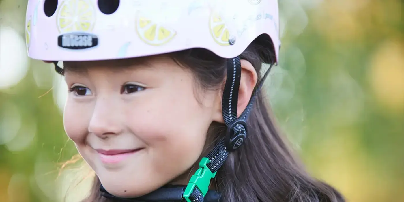 Närbild på ett barn med cykelhjälm på huvudet.